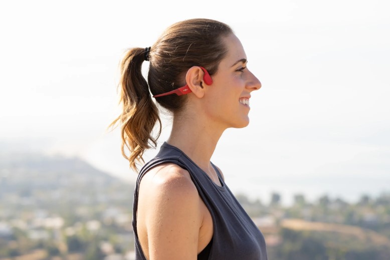 A girl is listening to music with bone conduction headphones